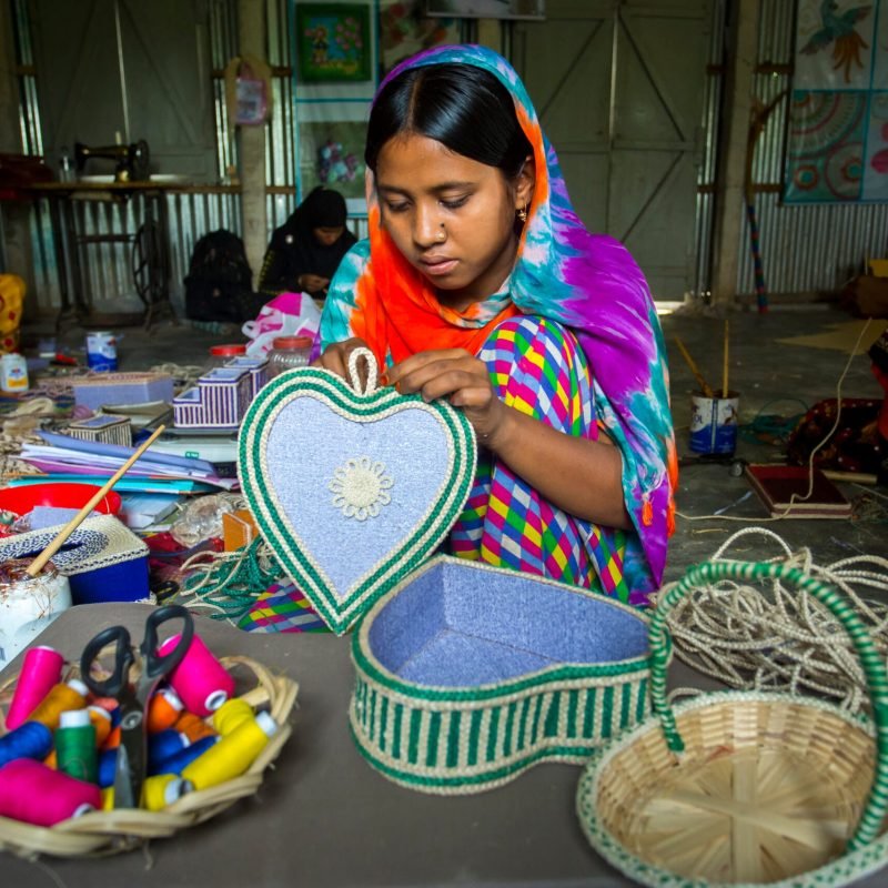 Bangladesh – May 13, 2018: A village Handicraft maker girl are making on some showpiece boxes using on pineapple fiber at Madhupur, Tangail.